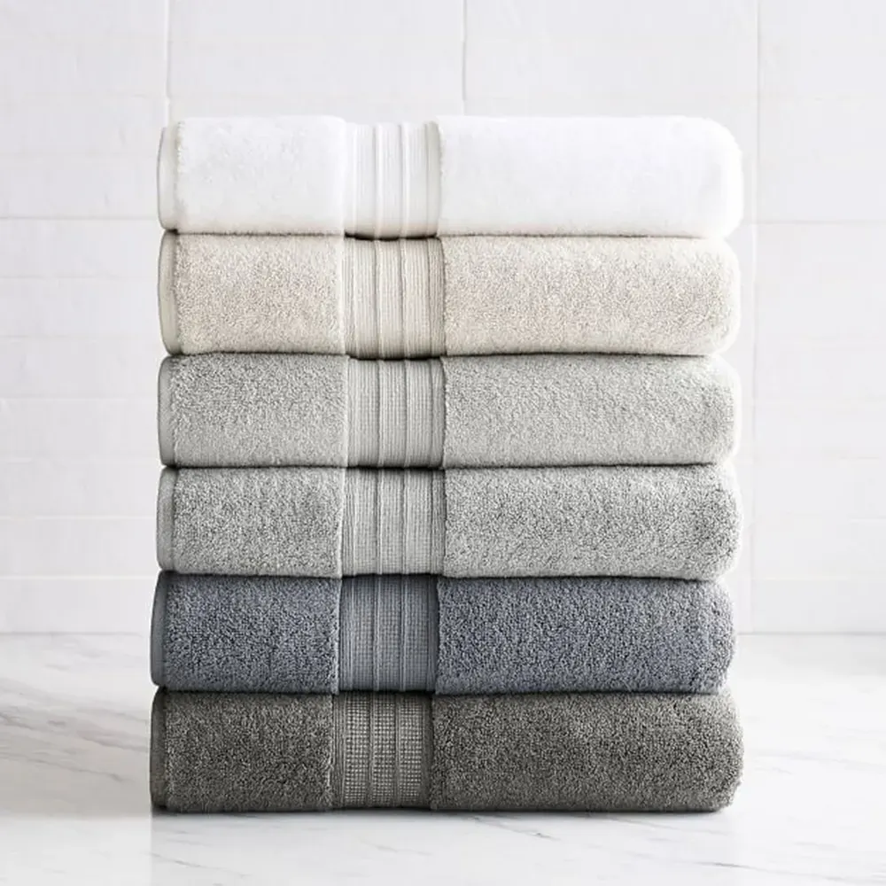 Stack of six folded bath towels shading from white through grey to charcoal, each with a ribbed dobby border